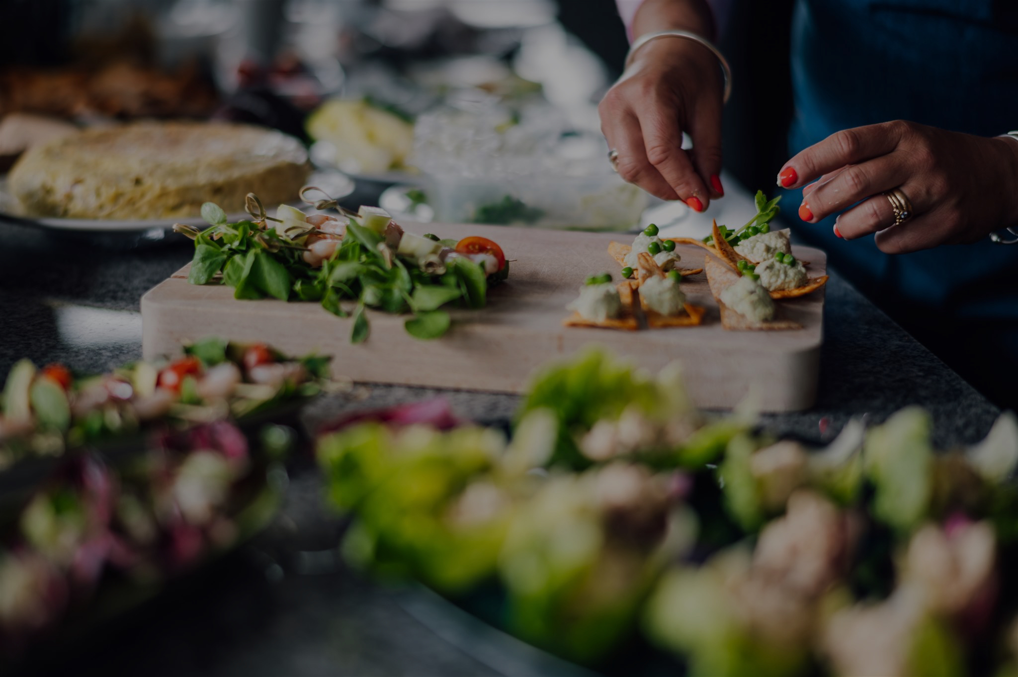 Chef finishing canapés on a wooden board