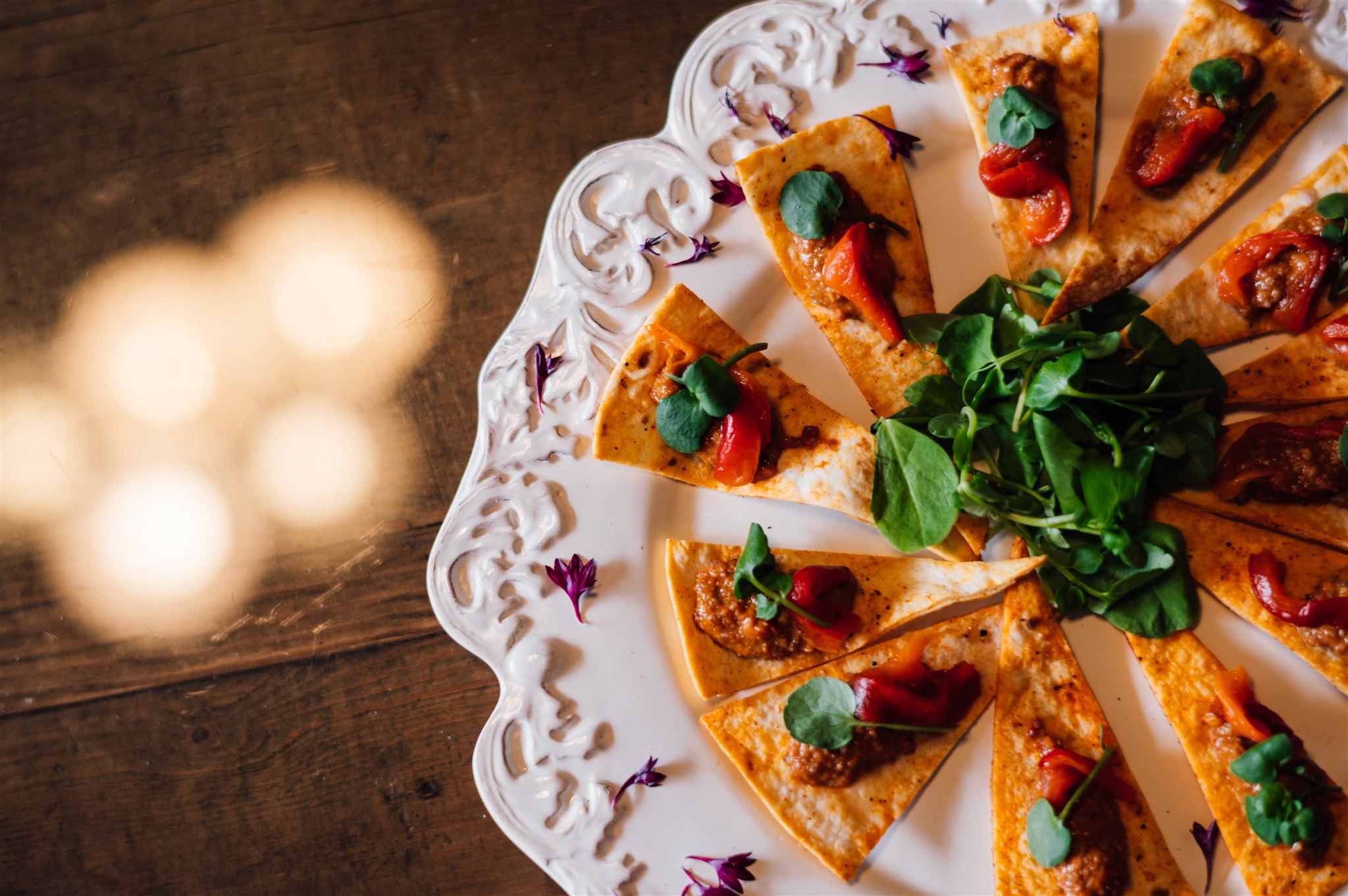 Flatbread canapés with roasted peppers and watercress on an ornate white plate